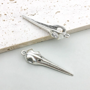 Detailed view of silver bird skull pendants with realistic bone textures and hanging loops