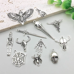 Detailed view of assorted vintage silver gothic skull and sword charms for DIY jewelry making
