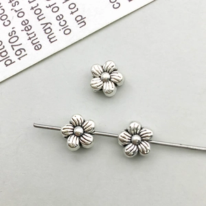 Macro view of three vintage silver flower alloy spacer beads for DIY jewelry design