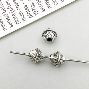Macro detail of vintage silver alloy spacer beads with ethnic embossed floral patterns