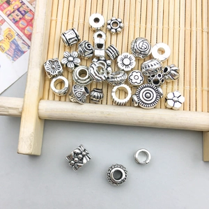 Macro detail of vintage silver alloy spacer beads with various floral and geometric patterns