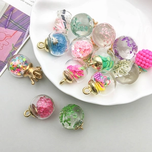 Macro shot of glass ball charms filled with colorful dried flowers and golden crown caps