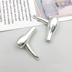 Macro detail of silver hairdryer charms for DIY jewelry making featuring polished finish
