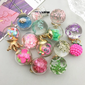 Macro shot of glass bottle pendants with dried flowers and colorful star sequins