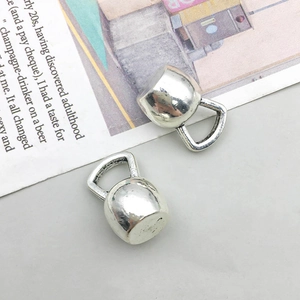 Vue détaillée de deux breloques kettlebell en argent vintage pour création bijoux DIY