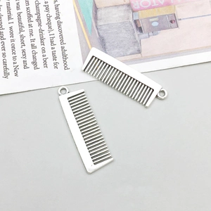 Macro shot of two antique silver comb-shaped alloy charms for DIY jewelry making