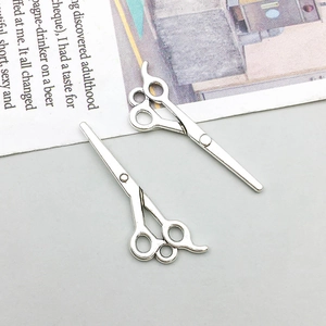 Detailed view of silver antique alloy hair stylist scissor charms for DIY jewelry making