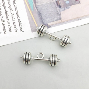 Vue macro de deux pendentifs haltères en alliage argenté vintage pour bijoux DIY