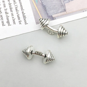 Gros plan de pendentifs haltères en argent antique pour création de bijoux DIY