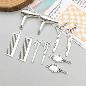 Detailed macro view of antique silver hair stylist charms including scissors and dryer