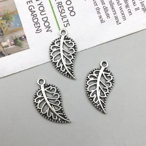 Detailed view of three vintage silver hollow leaf pendants for DIY jewelry making