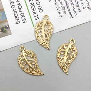Detailed close-up of hollow golden leaf charms with intricate veins for DIY jewelry