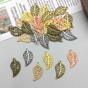 Detailed macro view of hollow leaf-shaped alloy pendants in four metallic color finishes