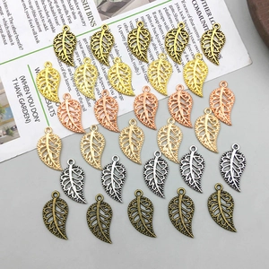 Macro detail of hollow leaf alloy pendants in five metallic colors for DIY jewelry making