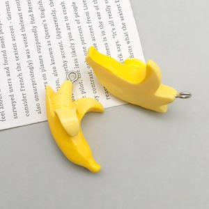 Macro detail of cute resin banana pendants for DIY jewelry making with metal rings
