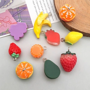 Detailed view of mixed resin fruit charms including strawberry and banana for DIY jewelry
