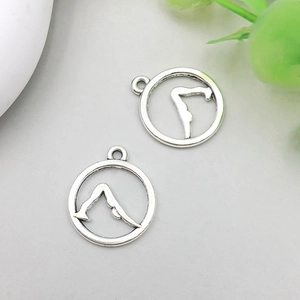 Detailopname van antieke zilveren yoga-hanger met yoga-houding op een grijze achtergrond
