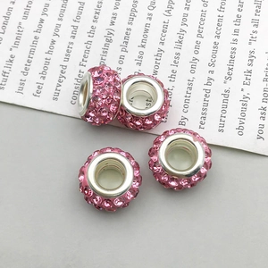 Detalle de cuatro charms pavé de cristales rosas con agujeros grandes para pulseras DIY