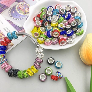 Detalle de dijes con pavé de diamantes de imitación y pulsera DIY bañada en plata