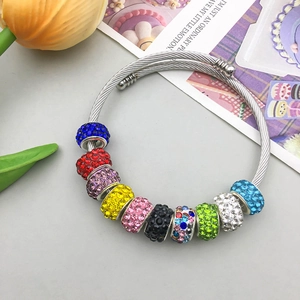 Detalle de cuentas de cristal de colores en una pulsera de cable plateado trenzado