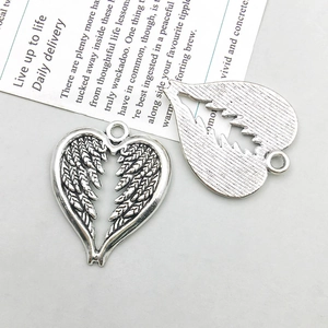 Detailed front and back view of silver heart wing pendant with vintage texture