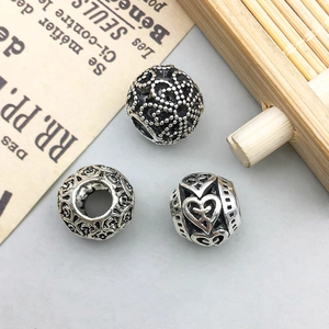 Macro detail of vintage silver hollow flower and heart charms for DIY jewelry making