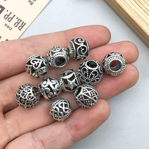 Antique silver hollow flower bead charms for DIY jewelry making held in hand