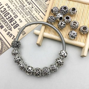 Detail of vintage silver hollow beads with intricate floral star patterns on a spring bracelet