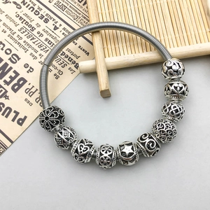 Vintage silver hollow flower charm bead on a flexible spring bangle bracelet