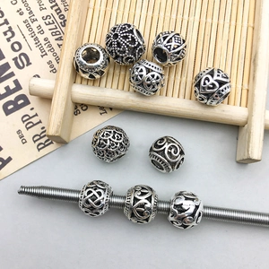 Macro detail of vintage silver hollow alloy beads with heart and vortex patterns