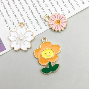 Macro detail of mixed enamel flower charms with daisy and cherry blossom for DIY jewelry