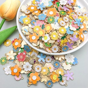 Close-up of colorful enamel flower charms in a ceramic plate for DIY jewelry making