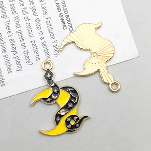 Macro detail of double-sided enamel moon and star charms for DIY jewelry making