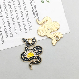 Detail of snake enamel pendant showing black sun pattern and golden textured back