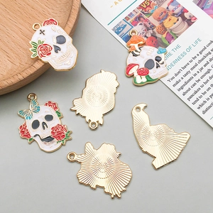 Detail of colorful enamel skull pendants with roses and mushrooms for DIY jewelry