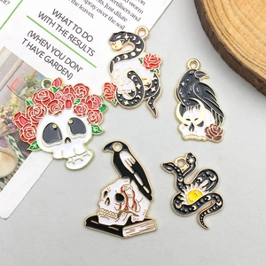 Detailed close-up of gothic Halloween enamel charms including skulls, crows, and snakes