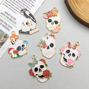 Detailed flat lay of gothic skull enamel charms with floral and mushroom motifs for DIY jewelry