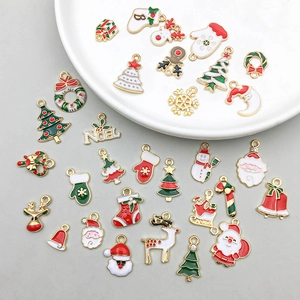 Dettaglio dei ciondoli natalizi smaltati assortiti con Babbo Natale e renne