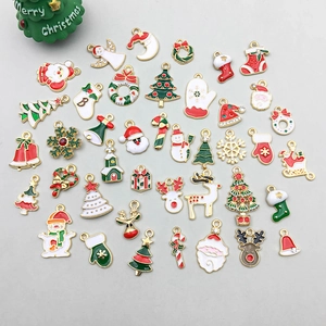 Vue à plat de breloques de Noël assorties en émail avec Père Noël et bonhommes de neige