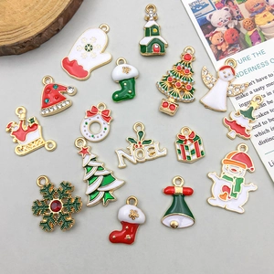 Dettaglio di ciondoli natalizi assortiti tra cui Babbo Natale, alberi e smalto colorato