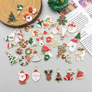 Vue à plat de breloques de Noël colorées en émail avec Père Noël et bonhommes de neige