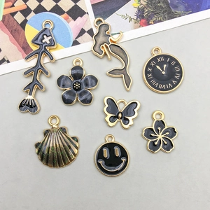 Set of 8 black enamel gold-plated charms including mermaid tail and floral designs for DIY