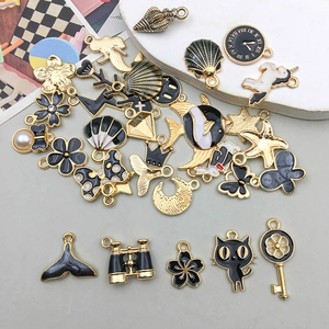 Detailed view of assorted black and gold enamel charms featuring marine and celestial motifs