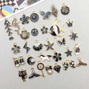 Close-up of black and white enamel alloy charms with gold edges for DIY jewelry making