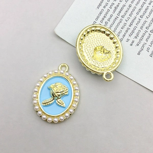 Detailed view showing both sides of a blue enamel rose pendant with pearl edge