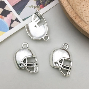 Détail de trois pendentifs en forme de casque de rugby argenté pour création de bijoux