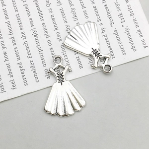 Detailed view of vintage silver dress-shaped alloy pendants for DIY jewelry making