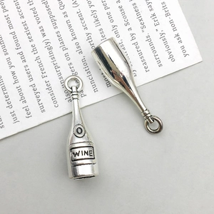 Macro detail of antique silver wine bottle pendants with clear WINE text engraving