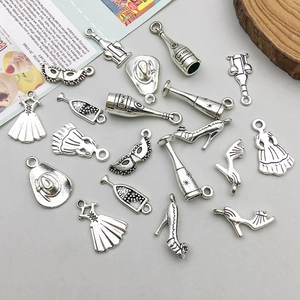 Macro shot of antique silver charms featuring wine bottles and fashion motifs for DIY jewelry