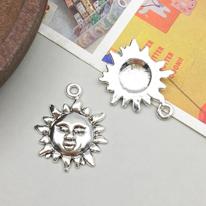Macro view of vintage silver alloy sun pendants showing anthropomorphic face details